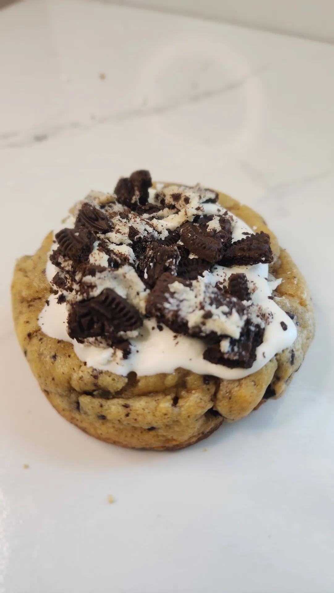 The Velvet Whisk cookies and cream cookie topped with cookie pieces and cream
