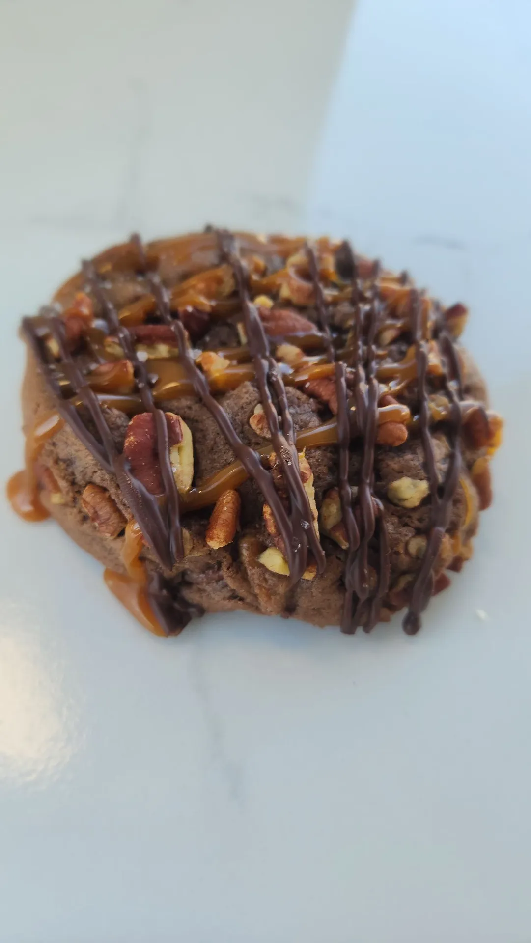 The Velvet Whisk turtle cookie topped with caramel, pecans, and chocolate